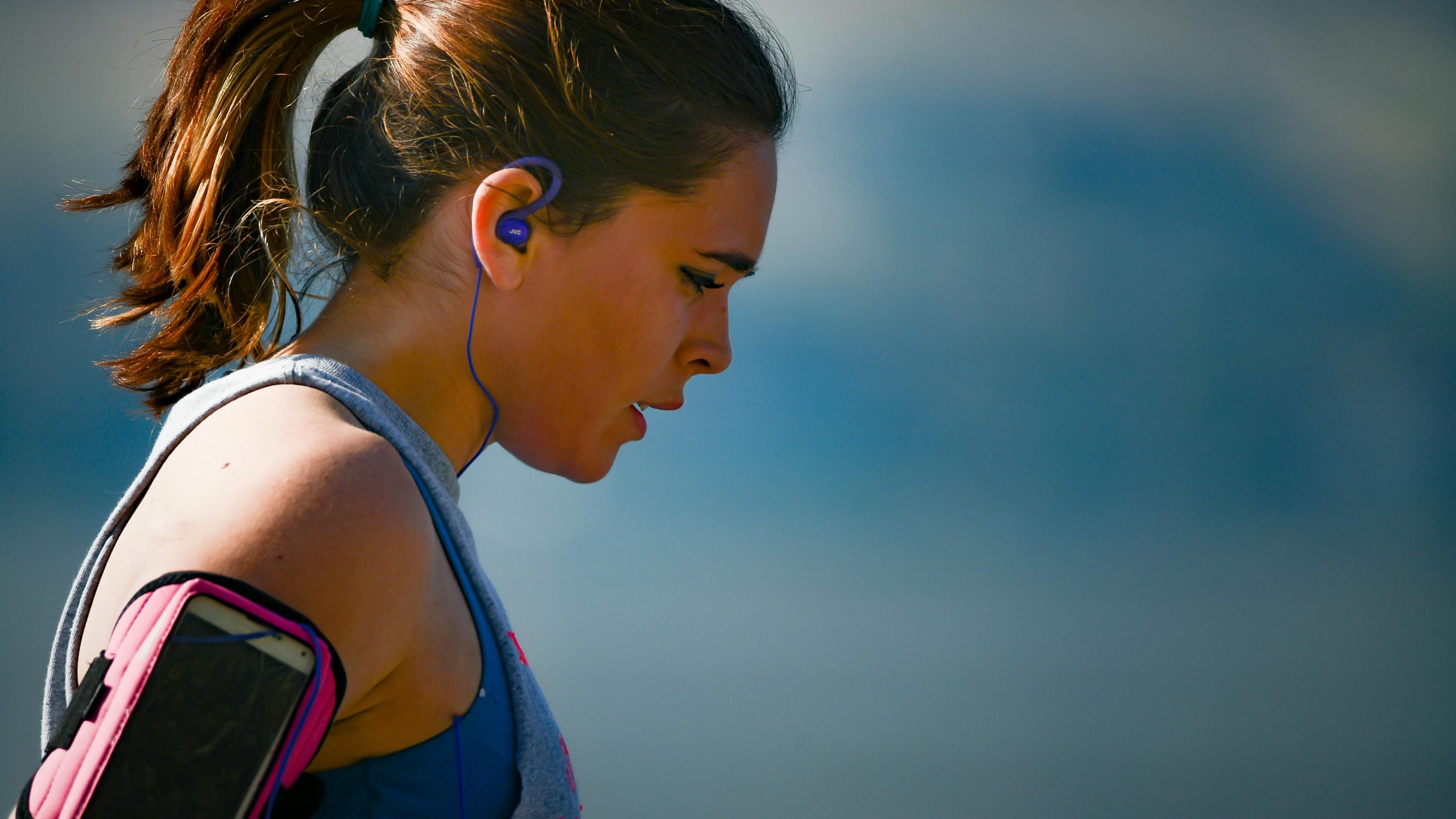 woman in fitness clothes and wearable tech looking exhausted after a workout