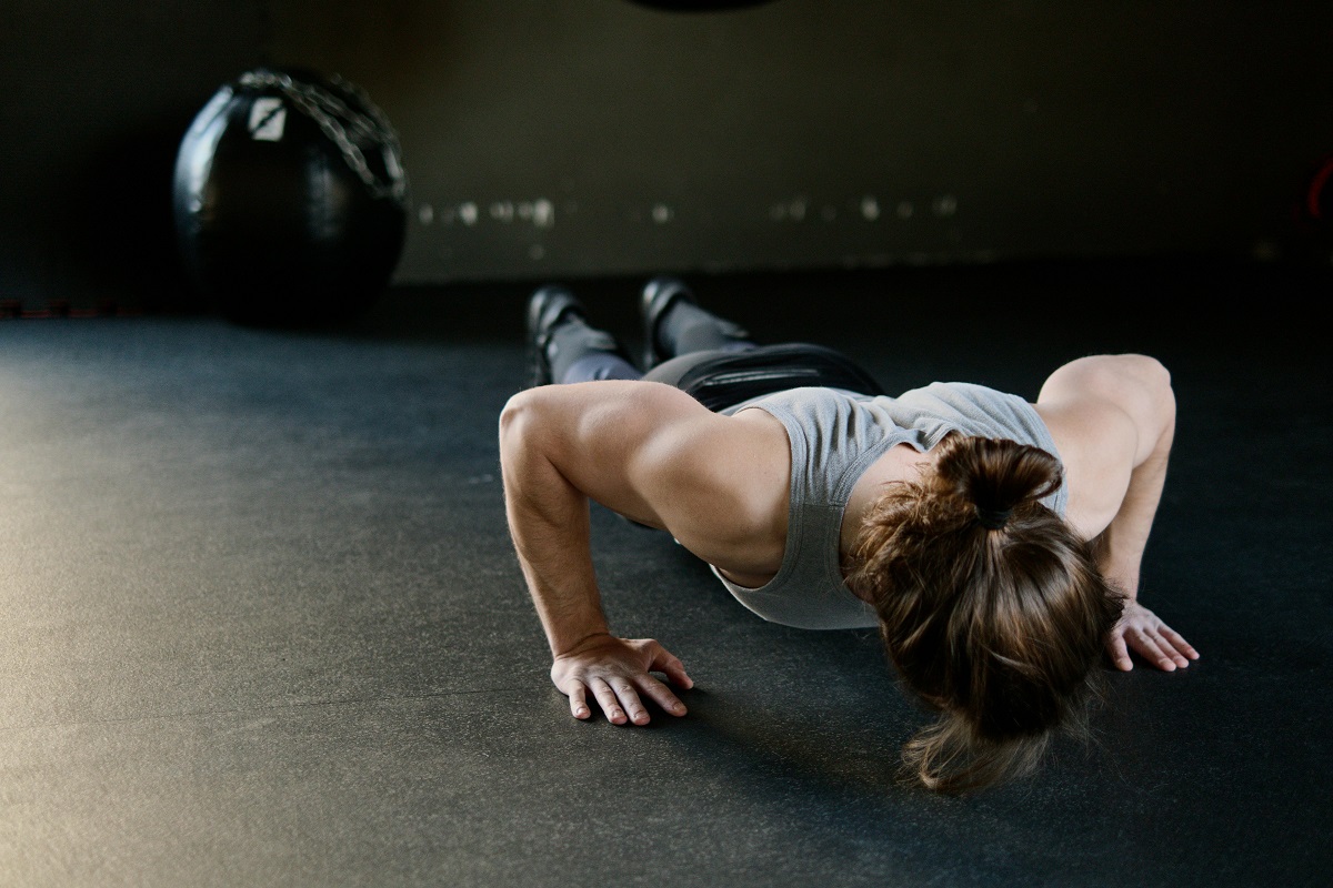 woman doing push-ups on the gym floor